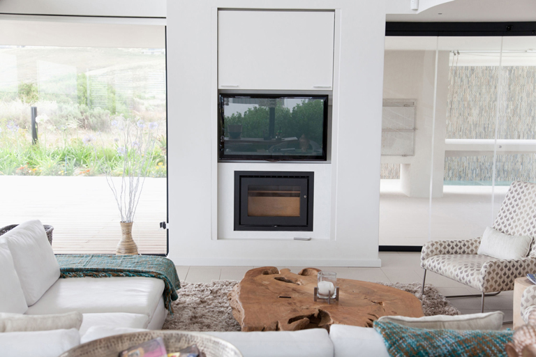 Sala de estilo minimalista con chimenea moderna, mesa orgánica de madera natural y mobiliario blanco – FRANCO HomeServices